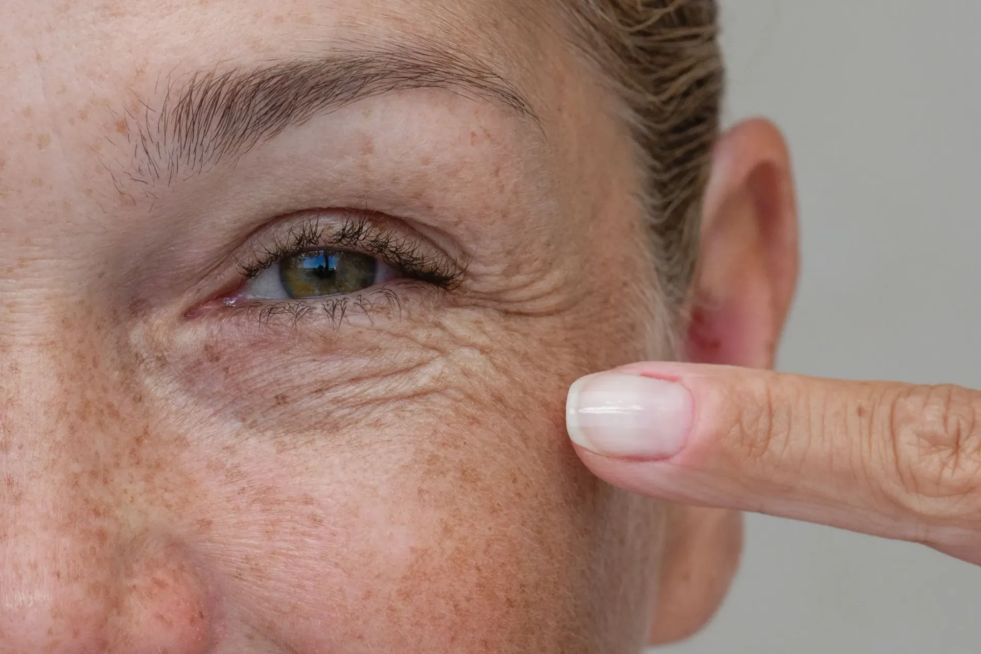 Woman examining fine lines and wrinkles at Eternal Wellness Medical Spa Traverse City